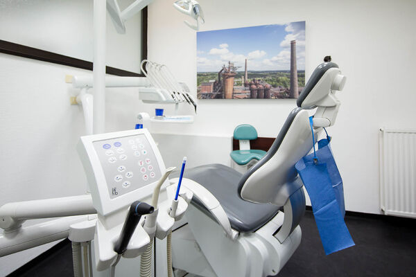 Moderne Zahnarztpraxis mit Behandlungsstuhl und zahnmedizinischen Geräten im Behandlungsraum.